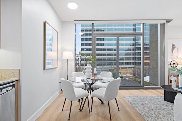 dining space with light hardwood / wood-style floors and expansive windows