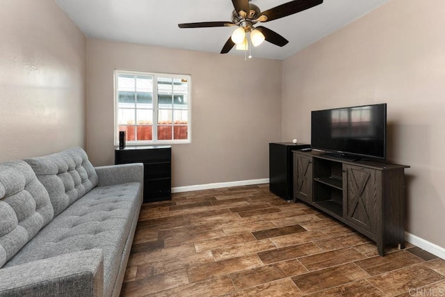 living room with a ceiling fan, dark wood-style flooring, and baseboards