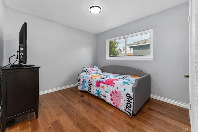 bedroom with baseboards and hardwood / wood-style flooring