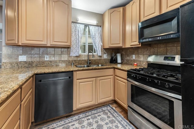 kitchen with stainless steel range with gas cooktop, tasteful backsplash, a sink, black microwave, and dishwashing machine