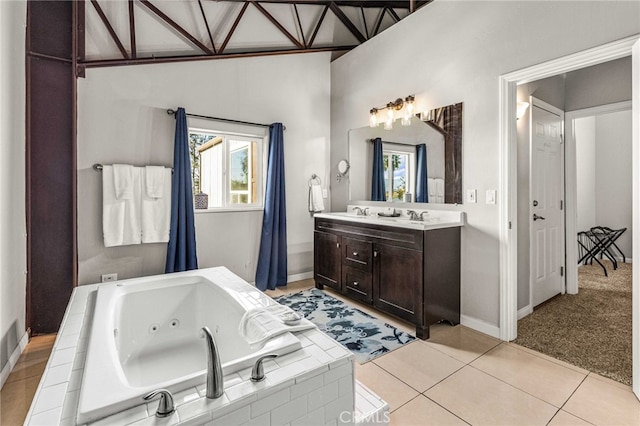 bathroom with a relaxing tiled tub, vanity, and tile patterned flooring