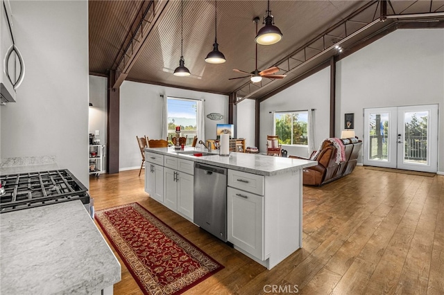 kitchen with white cabinetry, range, hanging light fixtures, a center island with sink, and dishwasher