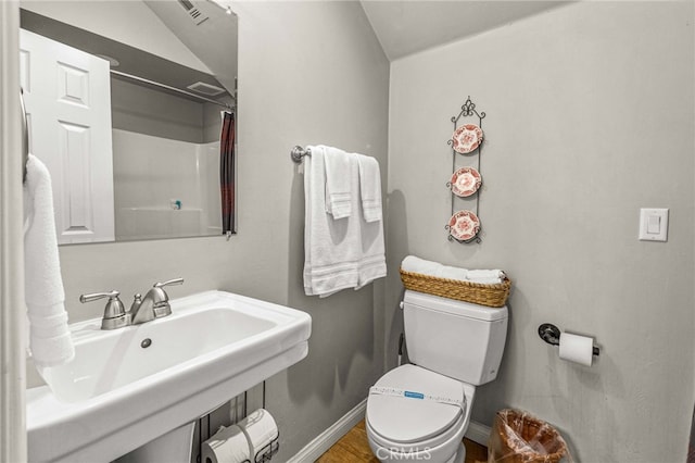 bathroom featuring walk in shower, sink, and toilet