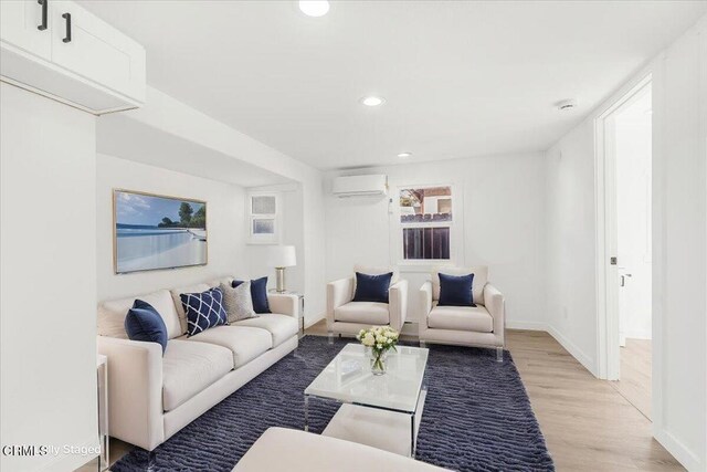 living room featuring light hardwood / wood-style flooring and a wall mounted air conditioner