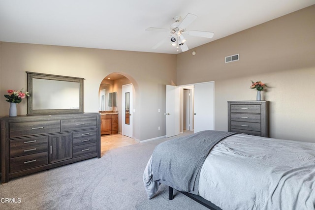 carpeted bedroom with ceiling fan and ensuite bath