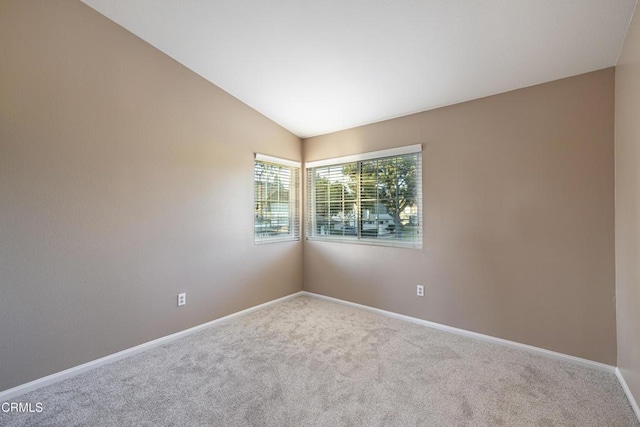 unfurnished room with vaulted ceiling and carpet