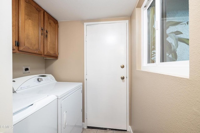 washroom with washer and dryer and cabinets