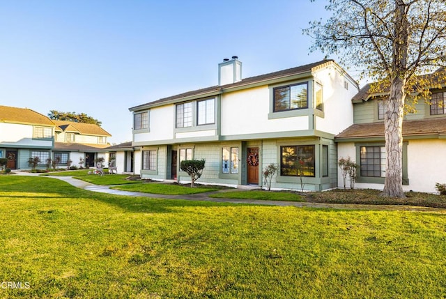 rear view of house featuring a yard