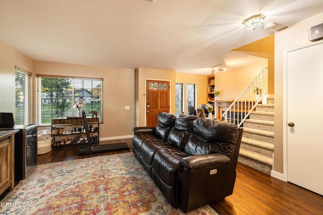 living room featuring dark wood-type flooring and a textured ceiling