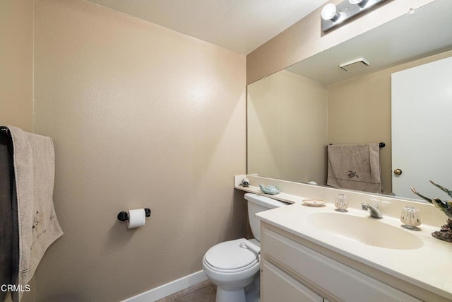 bathroom with toilet, tile patterned floors, and vanity