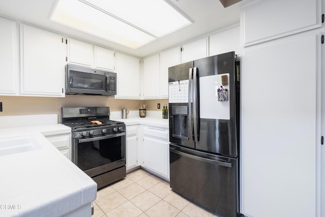 kitchen featuring light tile patterned flooring, stainless steel appliances, white cabinetry, and sink