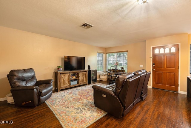 living room with dark hardwood / wood-style flooring and a textured ceiling