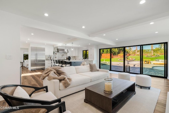 living room featuring beam ceiling and light wood-type flooring