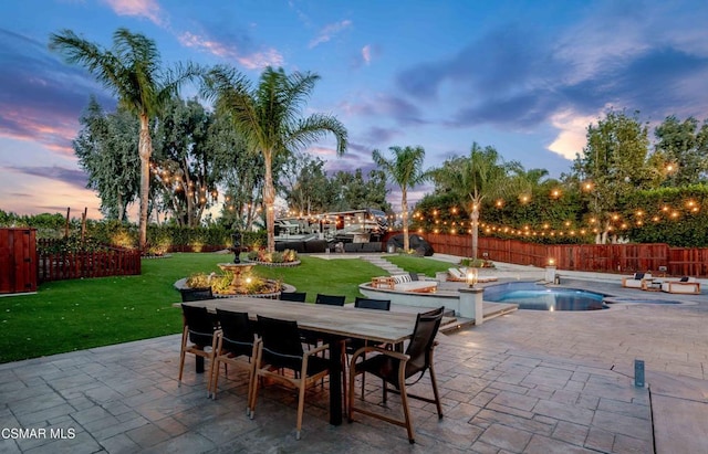 patio terrace at dusk with a fenced in pool and a lawn