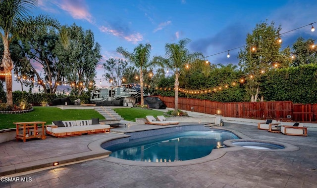 pool at dusk featuring an in ground hot tub, a yard, and a patio