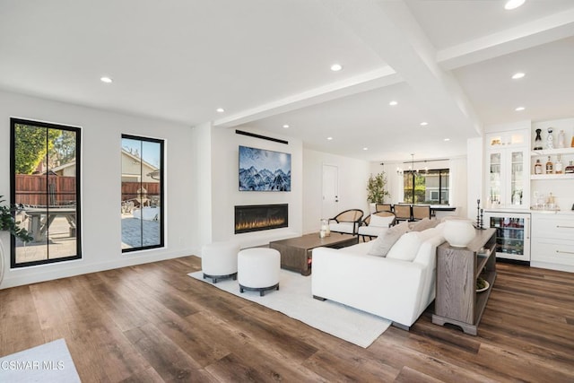 living room with wine cooler, dark hardwood / wood-style flooring, a wealth of natural light, and bar