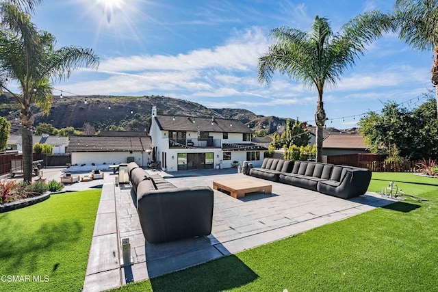 view of patio / terrace featuring a balcony, outdoor lounge area, exterior kitchen, and a mountain view