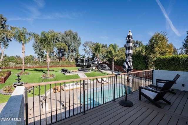 wooden terrace featuring a lawn, a patio area, and a fenced in pool