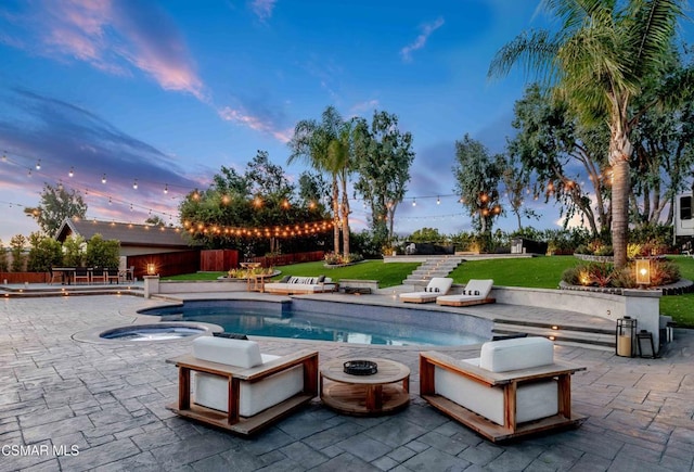 pool at dusk with a yard and a patio