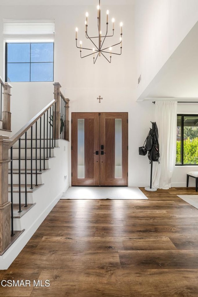 foyer entrance featuring dark hardwood / wood-style floors and a notable chandelier