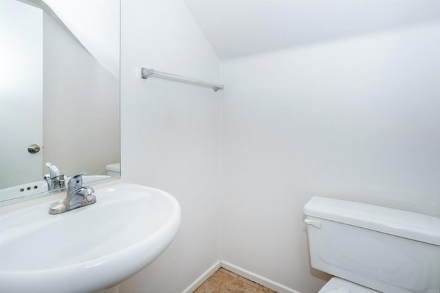 bathroom featuring toilet, tile patterned floors, and sink