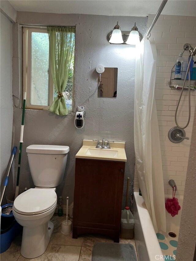 full bathroom featuring tile patterned floors, shower / bath combo with shower curtain, vanity, and toilet