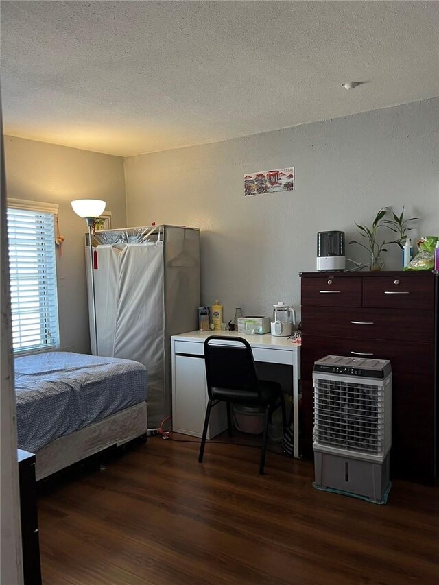 bedroom featuring a textured ceiling and dark hardwood / wood-style floors