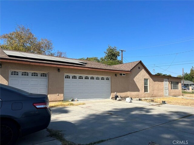 view of home's exterior featuring a garage and solar panels