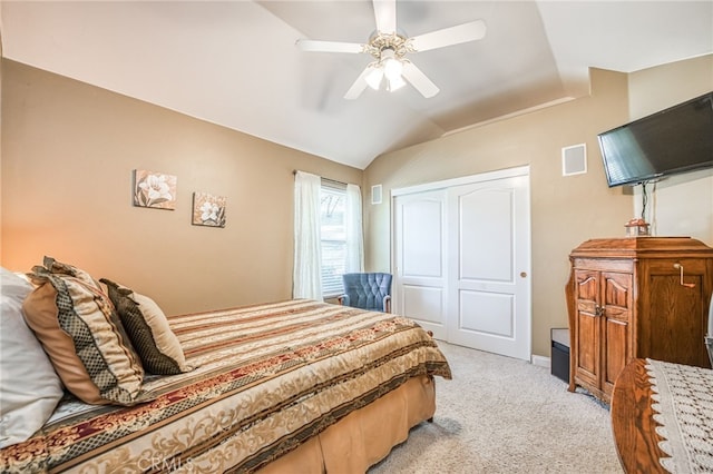 carpeted bedroom featuring a closet, lofted ceiling, and ceiling fan