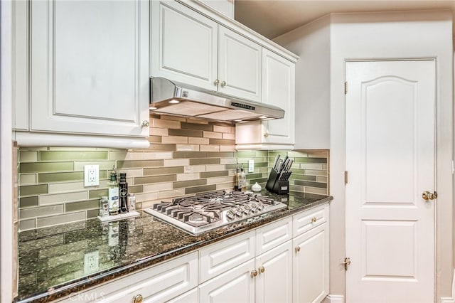 kitchen with stainless steel gas stovetop, white cabinetry, dark stone counters, and tasteful backsplash