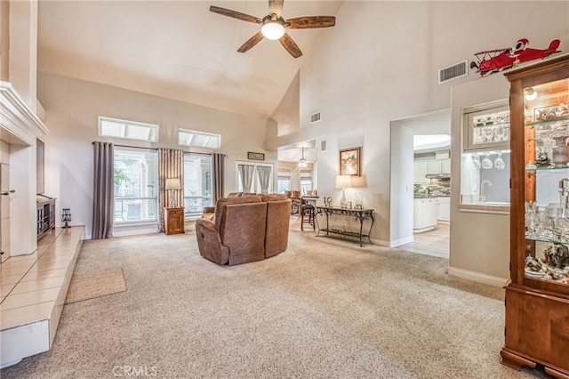 living room featuring ceiling fan, light colored carpet, sink, and high vaulted ceiling