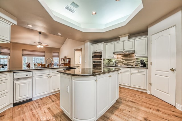 kitchen featuring a kitchen island, white cabinetry, kitchen peninsula, and dark stone counters