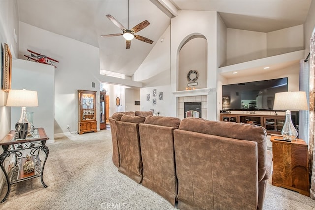 living room with high vaulted ceiling, ceiling fan, a fireplace, beamed ceiling, and light colored carpet