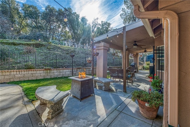 view of patio with ceiling fan and an outdoor fire pit