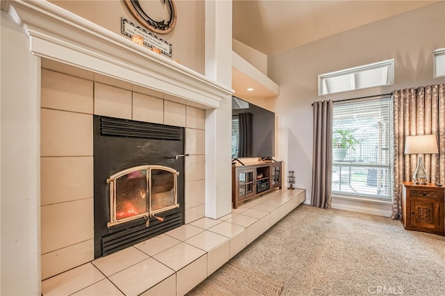 living room with light colored carpet and a tiled fireplace