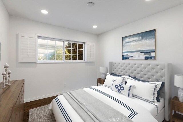 bedroom with dark hardwood / wood-style floors