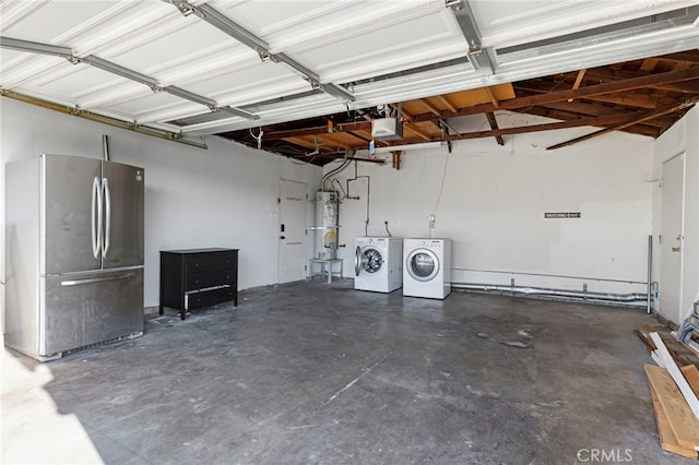 garage featuring a garage door opener, independent washer and dryer, stainless steel fridge, and strapped water heater