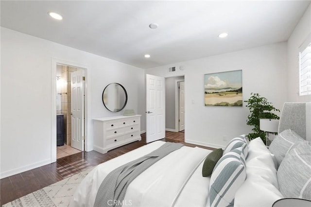 bedroom with ensuite bathroom and dark hardwood / wood-style floors