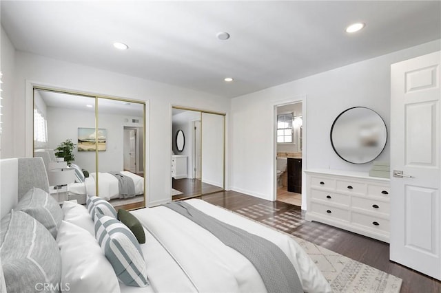 bedroom featuring multiple closets, dark wood-type flooring, and connected bathroom