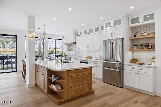 kitchen with open shelves, light wood-style floors, high quality fridge, and a sink