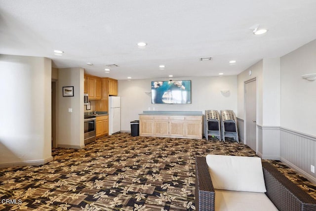 interior space featuring a wainscoted wall, recessed lighting, and visible vents