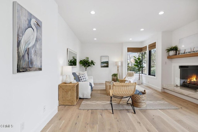 living area featuring a fireplace, recessed lighting, wood finished floors, and baseboards