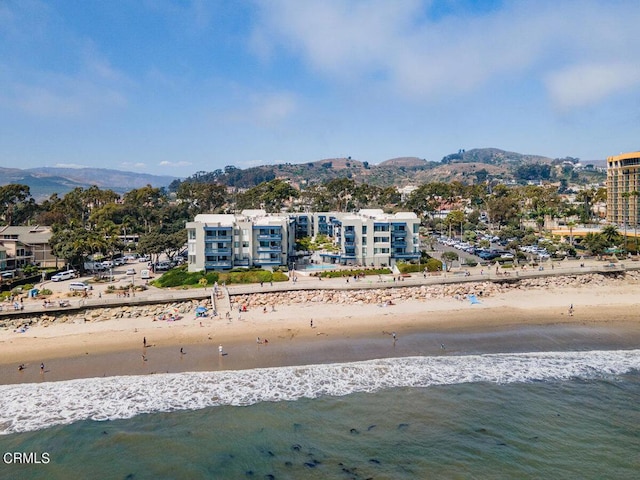 drone / aerial view featuring a water and mountain view and a beach view