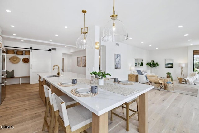 dining room featuring recessed lighting, light wood-style floors, and a barn door