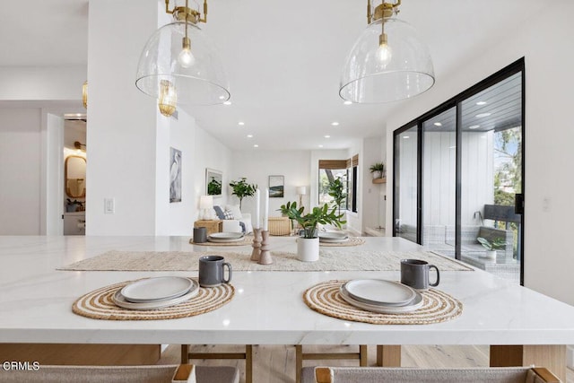 kitchen with recessed lighting, stone counters, pendant lighting, and open floor plan