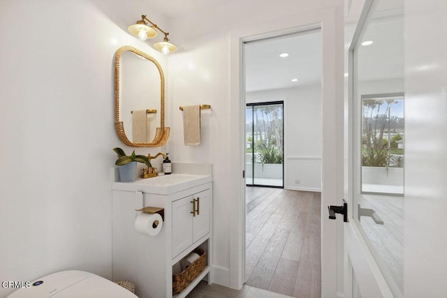 bathroom featuring recessed lighting, wood finished floors, and vanity