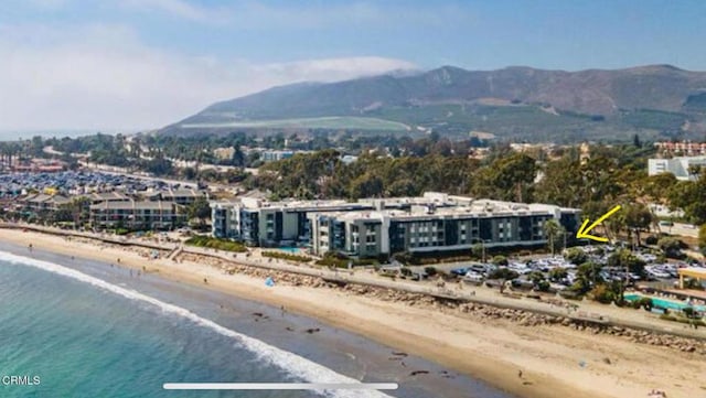 birds eye view of property featuring a water and mountain view and a view of the beach