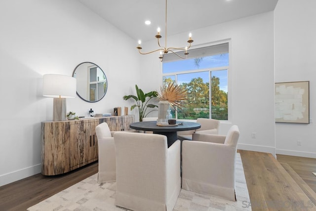 dining space featuring hardwood / wood-style floors and a chandelier