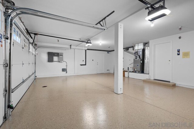 garage featuring a garage door opener, electric panel, and heating unit