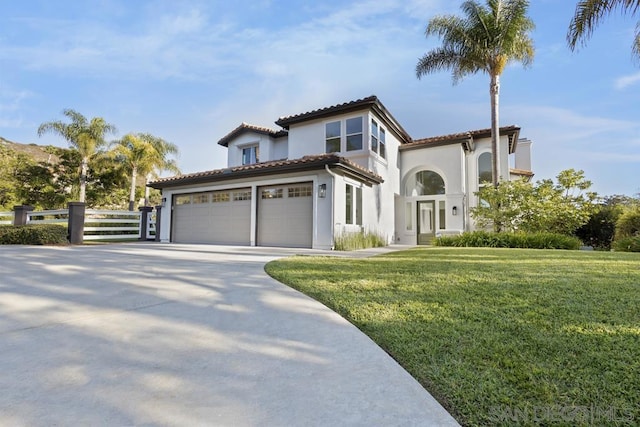 mediterranean / spanish house with a front yard and a garage